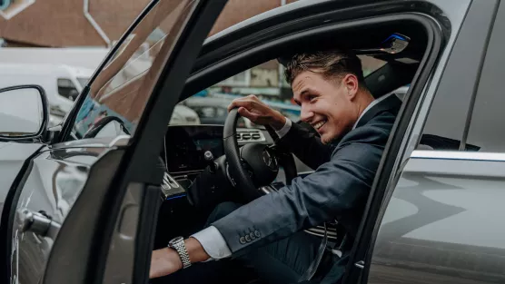 A private chauffeur opens the car door from inside