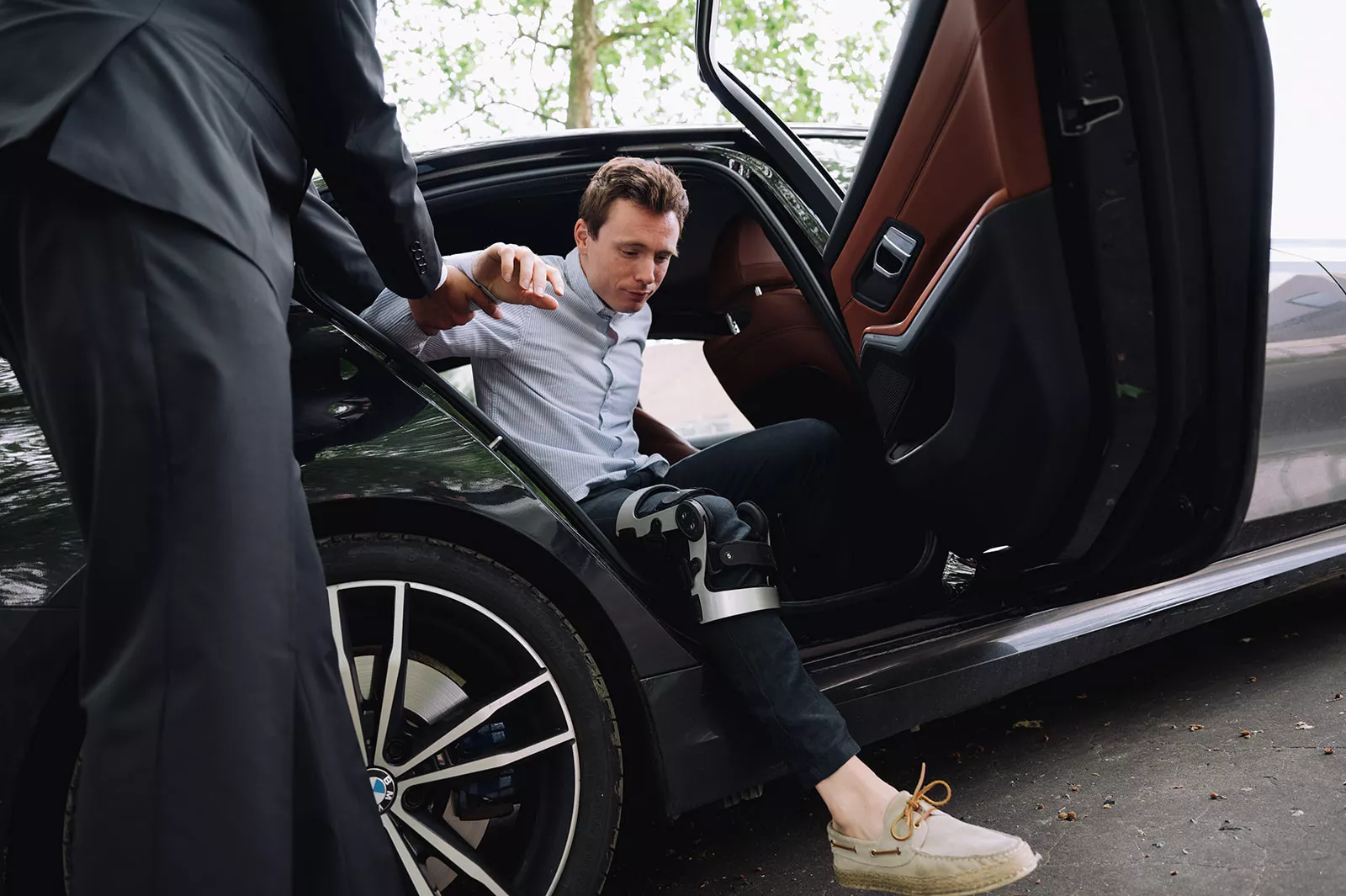 man with broken leg in backseat of the car